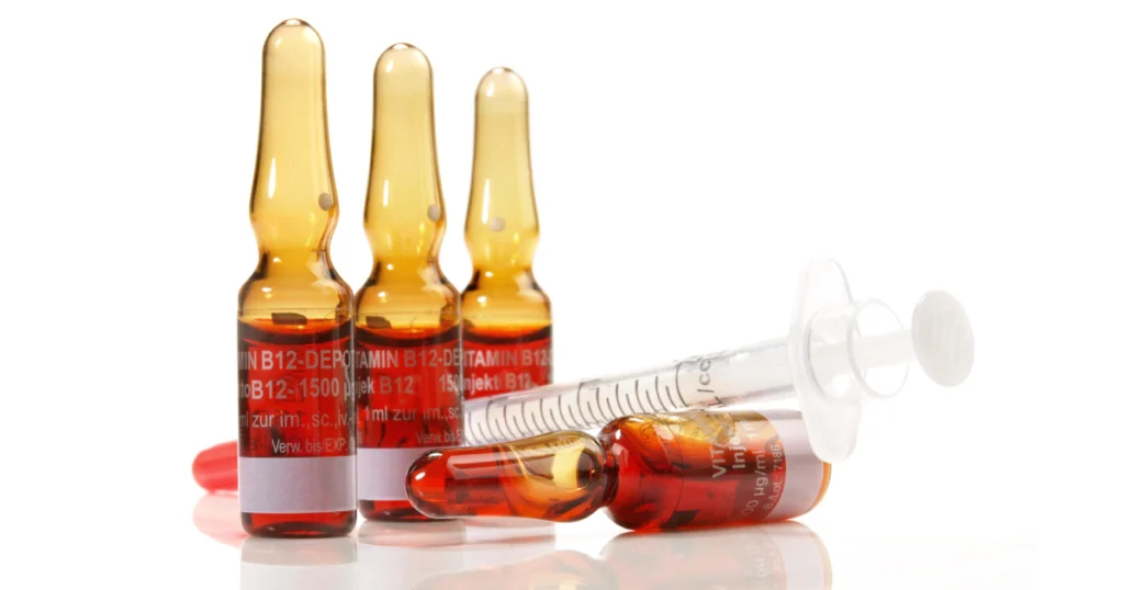 Vitamin B12 injection vials with a syringe on white background in Houston
